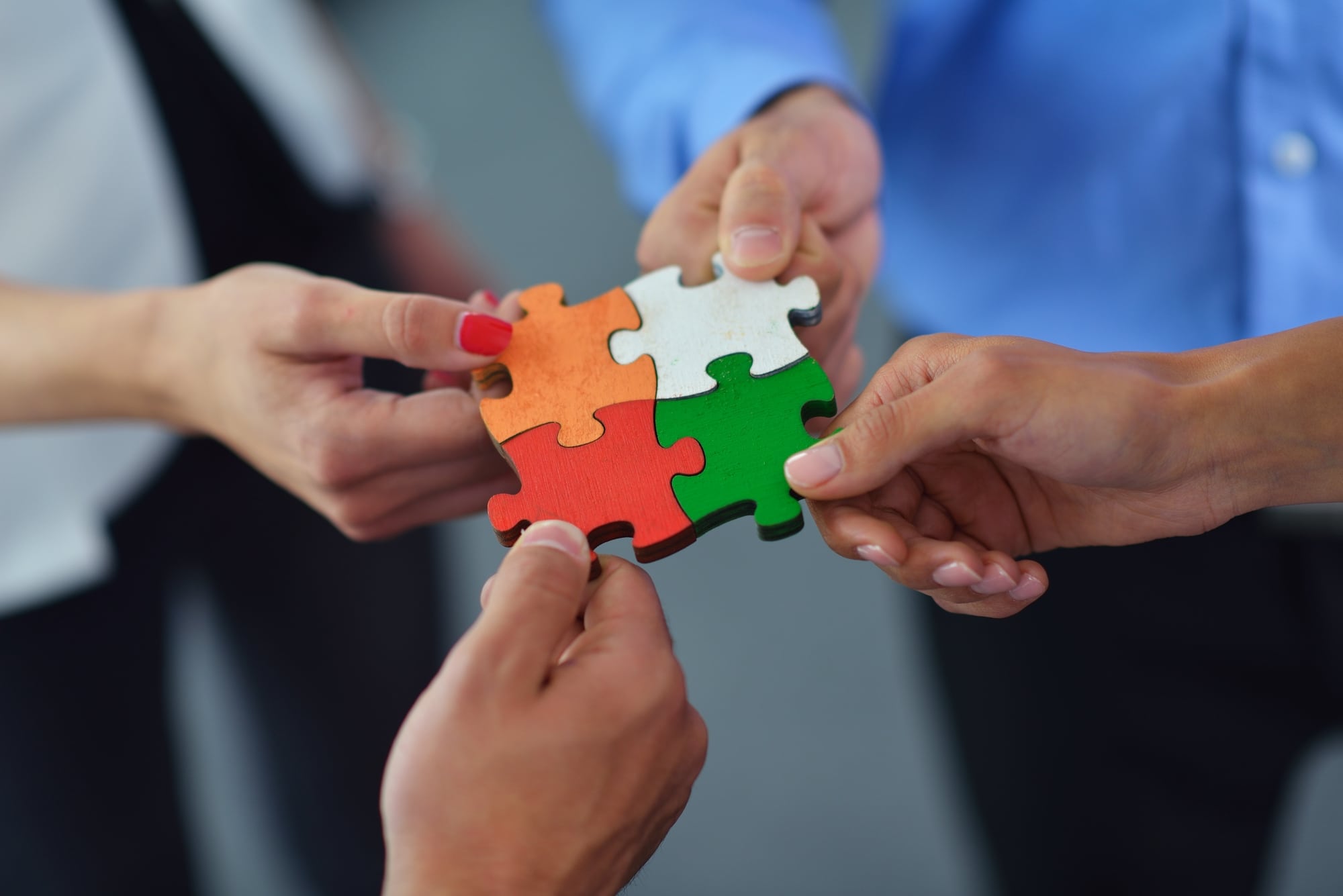 Group of business people assembling jigsaw puzzle Understanding Business Ecosystems – Another level of collaboration